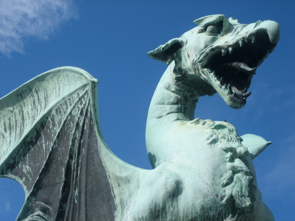 a large white dragon statue against a blue sky