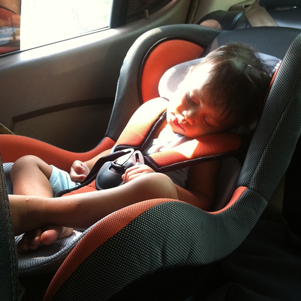 a young child sleeping in a car seat