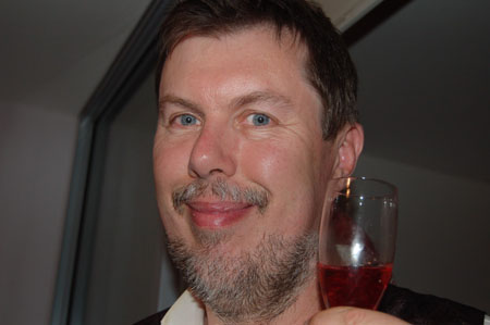 a man with a tie holding a glass of wine