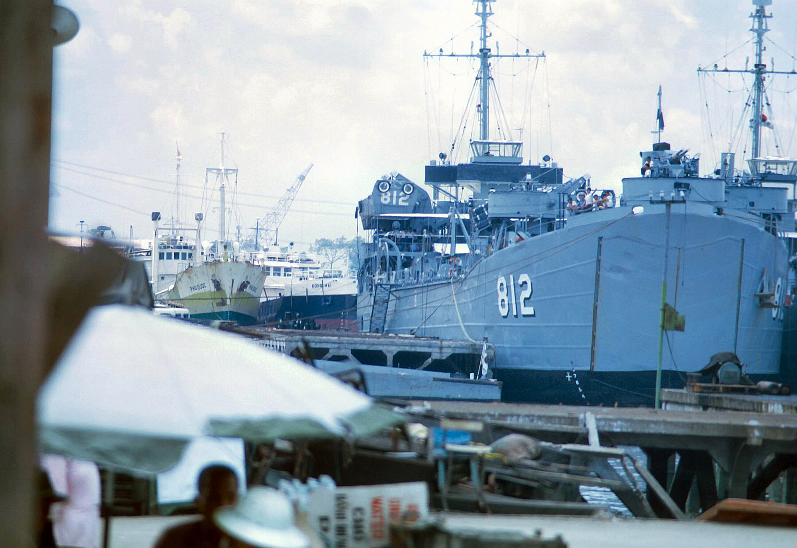 a navy ship docked at a dock in the water