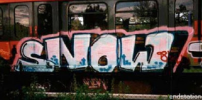 a red train is parked next to some graffiti
