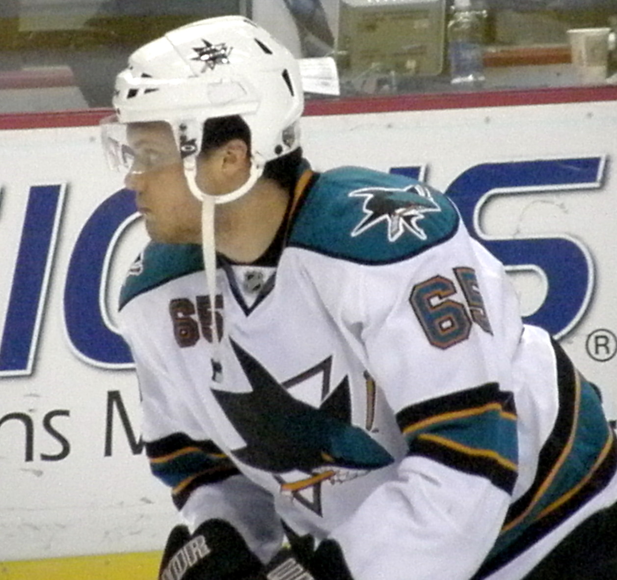 a man wearing a white hockey jersey and a helmet