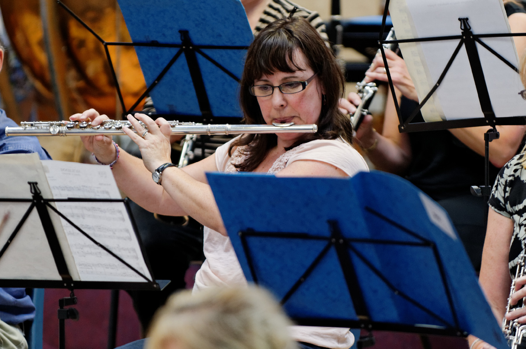 a woman playing the flute in front of a group of people