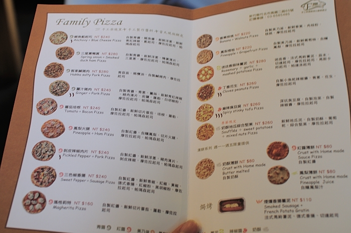 a person holding up a menu that includes a lot of food