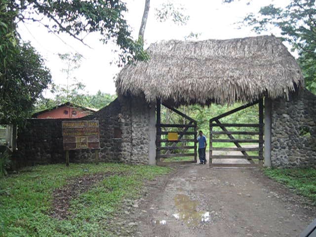 a person standing on a dirt road at a stone building