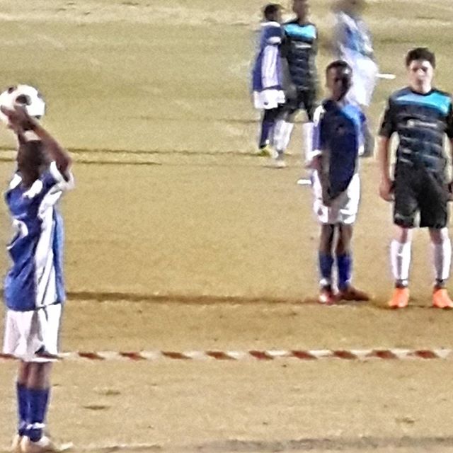 a group of soccer players playing soccer on a field