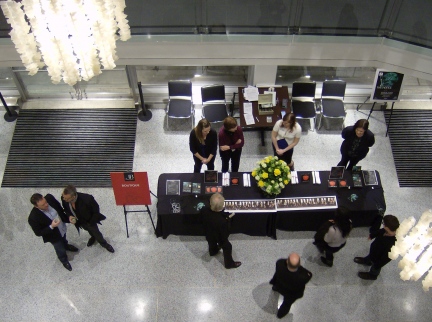 a group of people are standing around a table with flowers