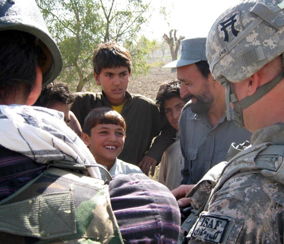 a man in a military uniform giving a group of children soing