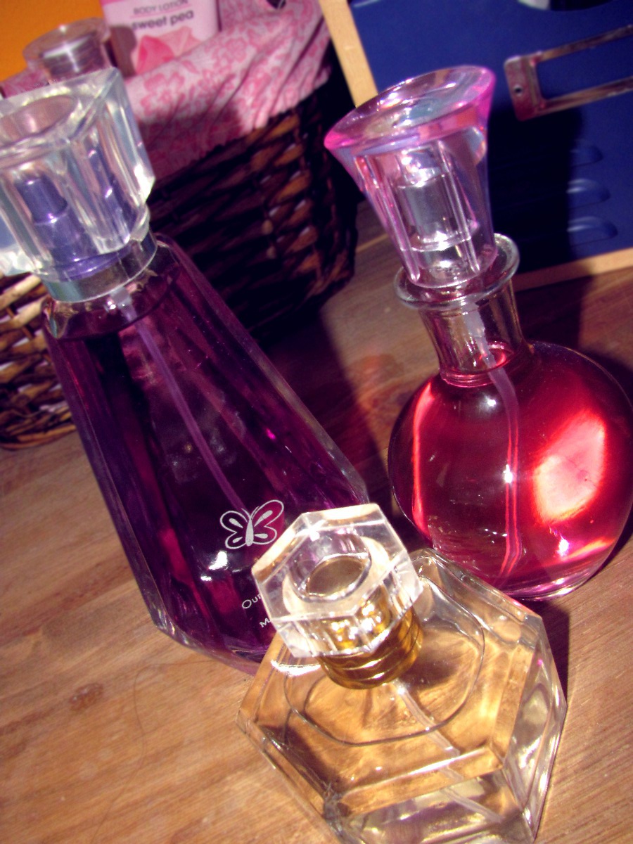 three glass bottles of perfume are next to each other