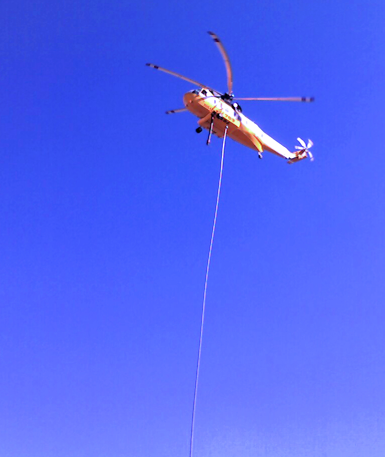 a helicopter flying through the blue sky on a sunny day