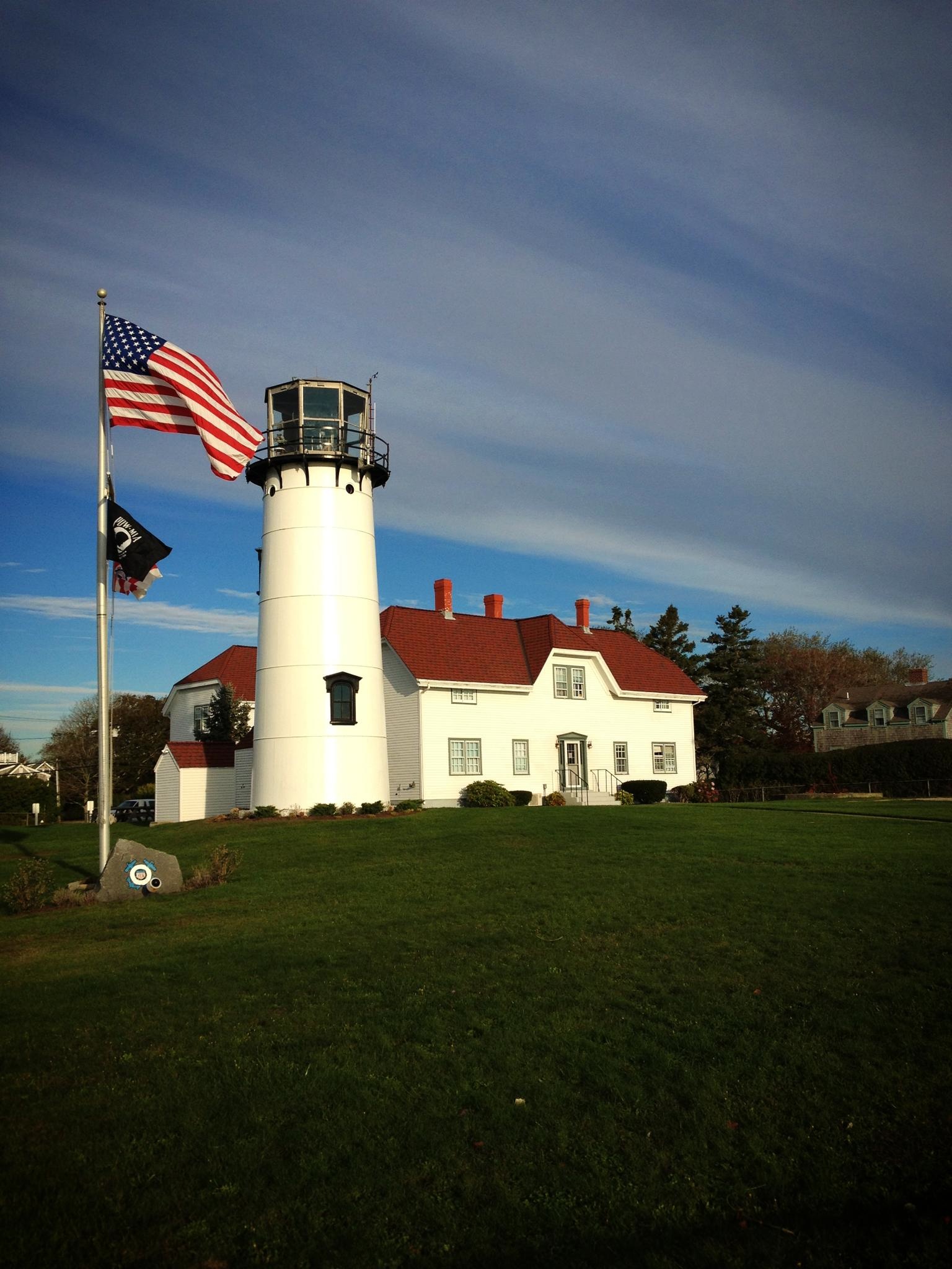 an american flag flies near a lighthouse