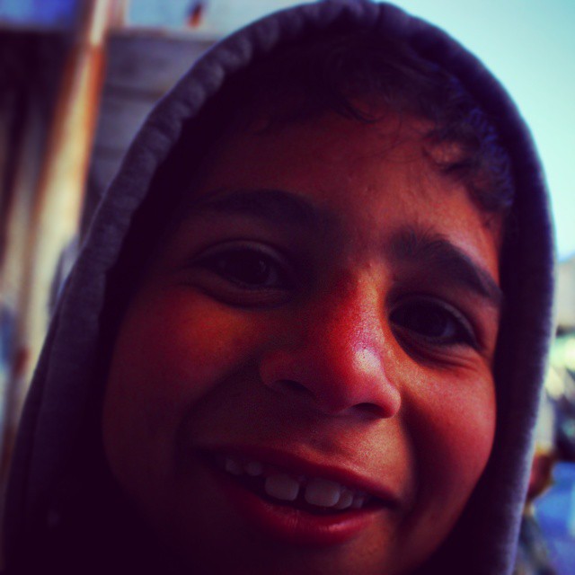 a close up of a child smiling with a street light in the background