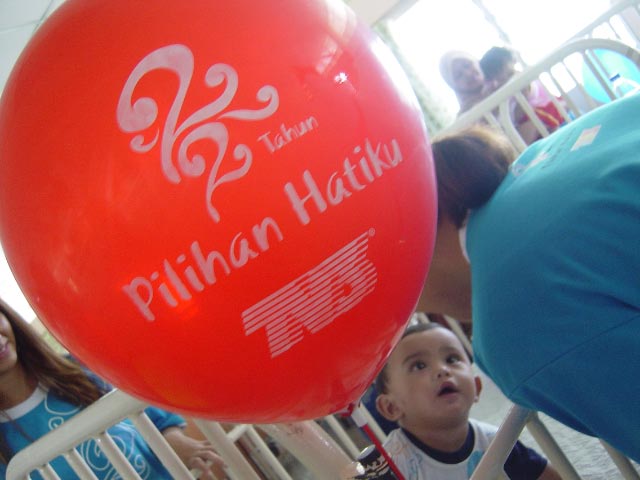a large red balloon with the logo of pakistan haiki and is being held by two people