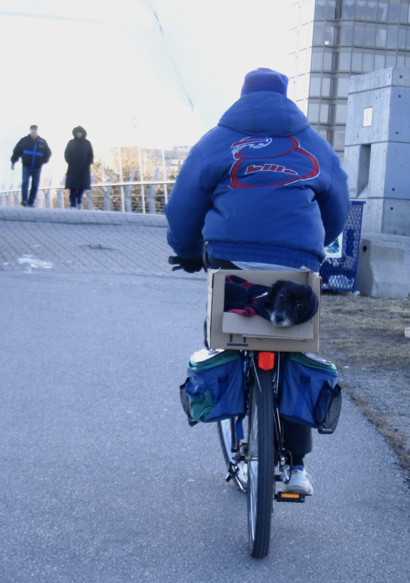 a man riding on the back of a bicycle in the middle of a road