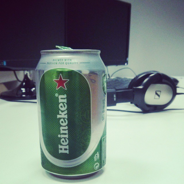 a can of heineken beer sitting in front of the computer