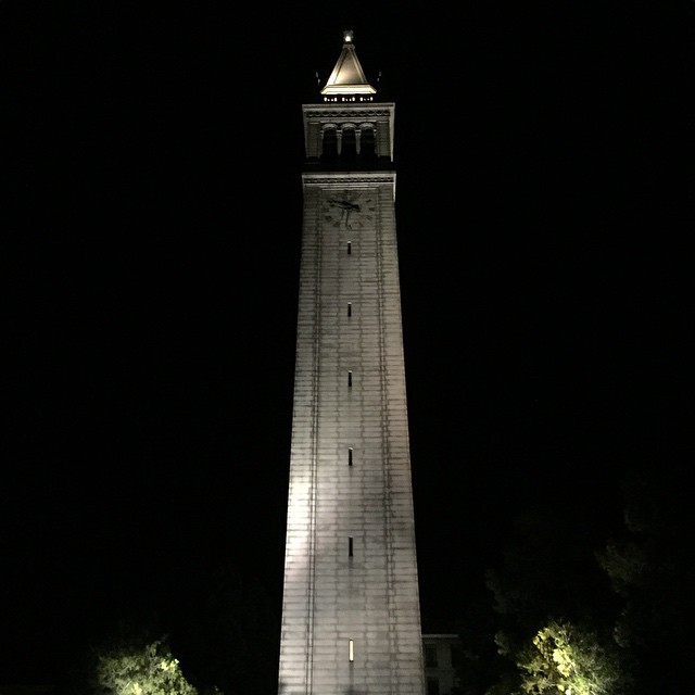 a clock tower with trees at night time