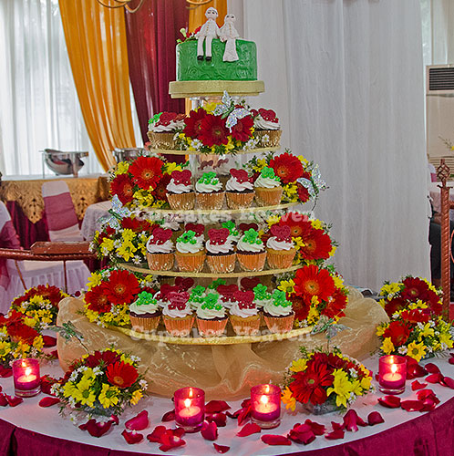 a wedding cake with cupcakes displayed in it