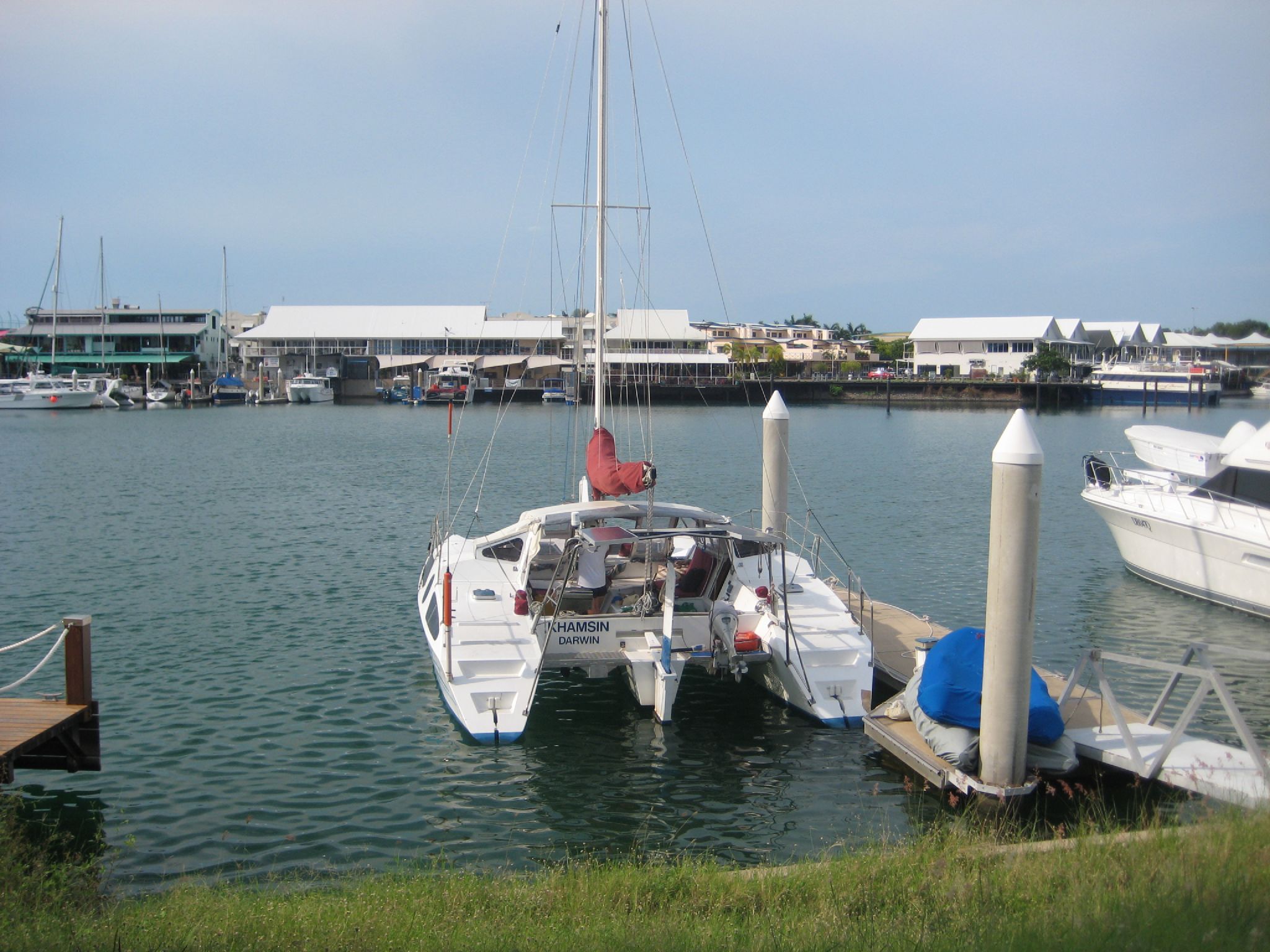 a white boat is docked in the water