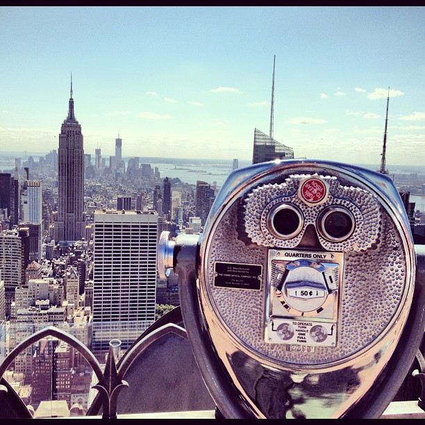 a couple of coin operated binoculars overlooks a city