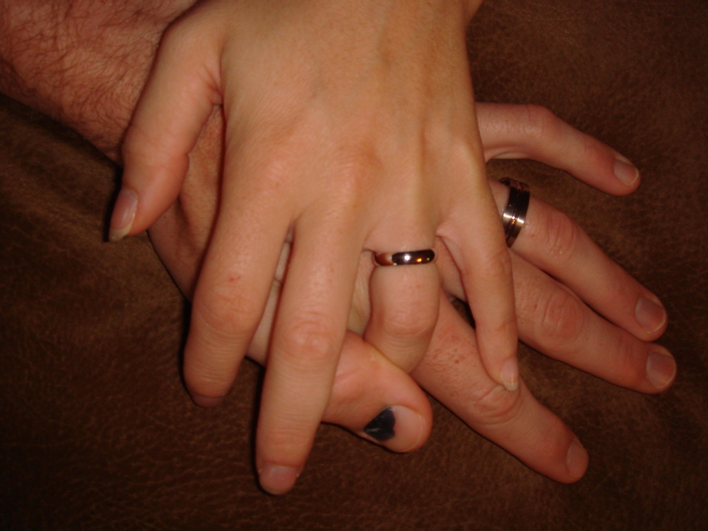 two people holding hands on a brown blanket