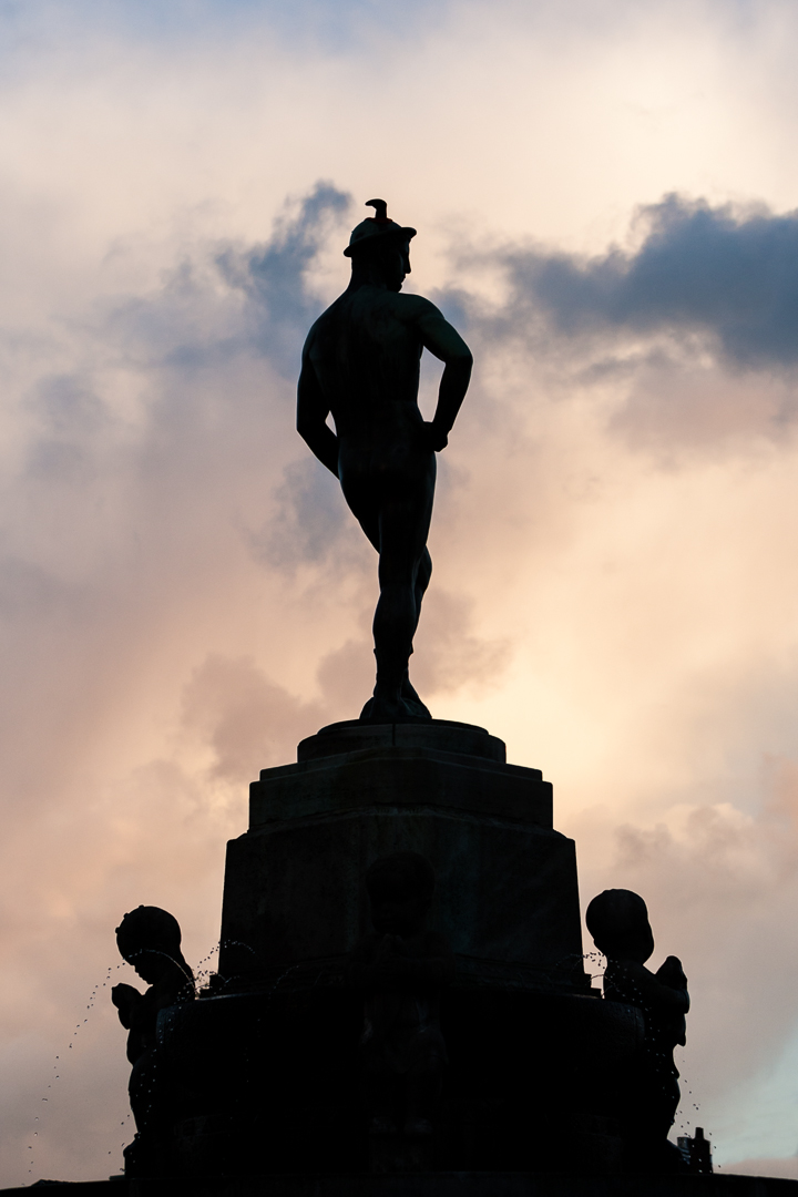 silhouette of a man wearing a top hat and holding his hands on hips