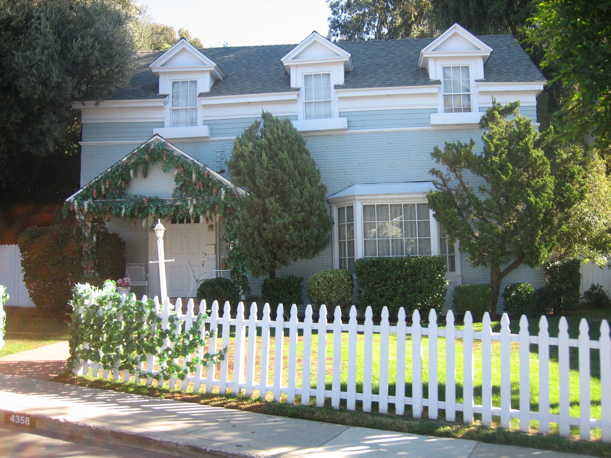 white picket fence in front of an older house