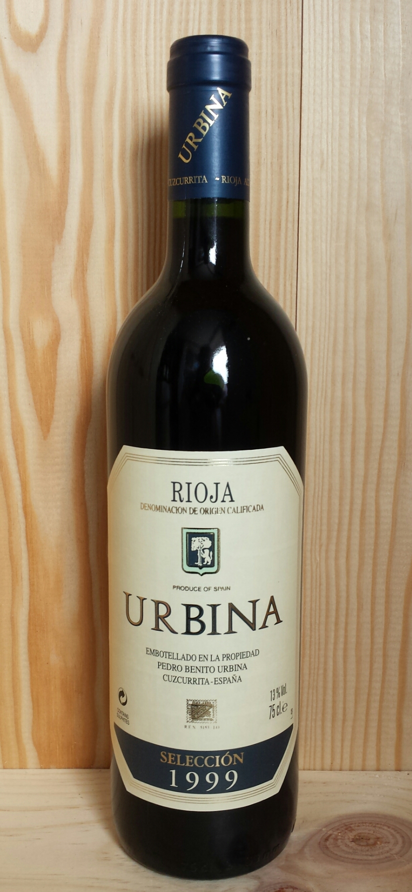 a bottle of wine with a tag in front of wooden paneled walls