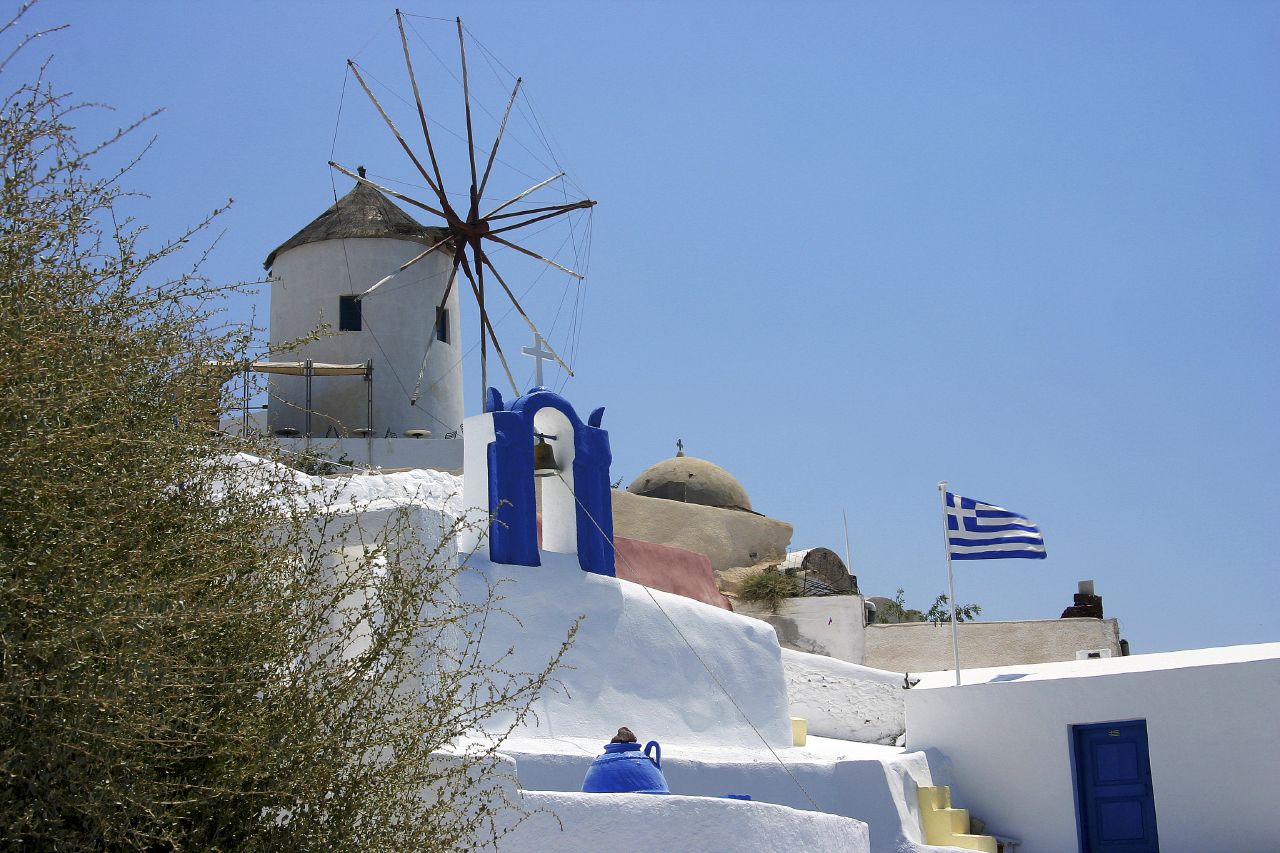 a white and blue house with a windmill on it