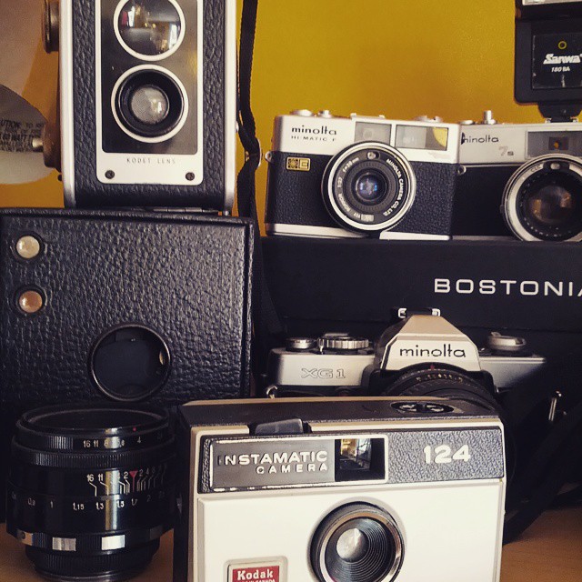 four old - fashioned camera and two old cameras sitting on top of each other