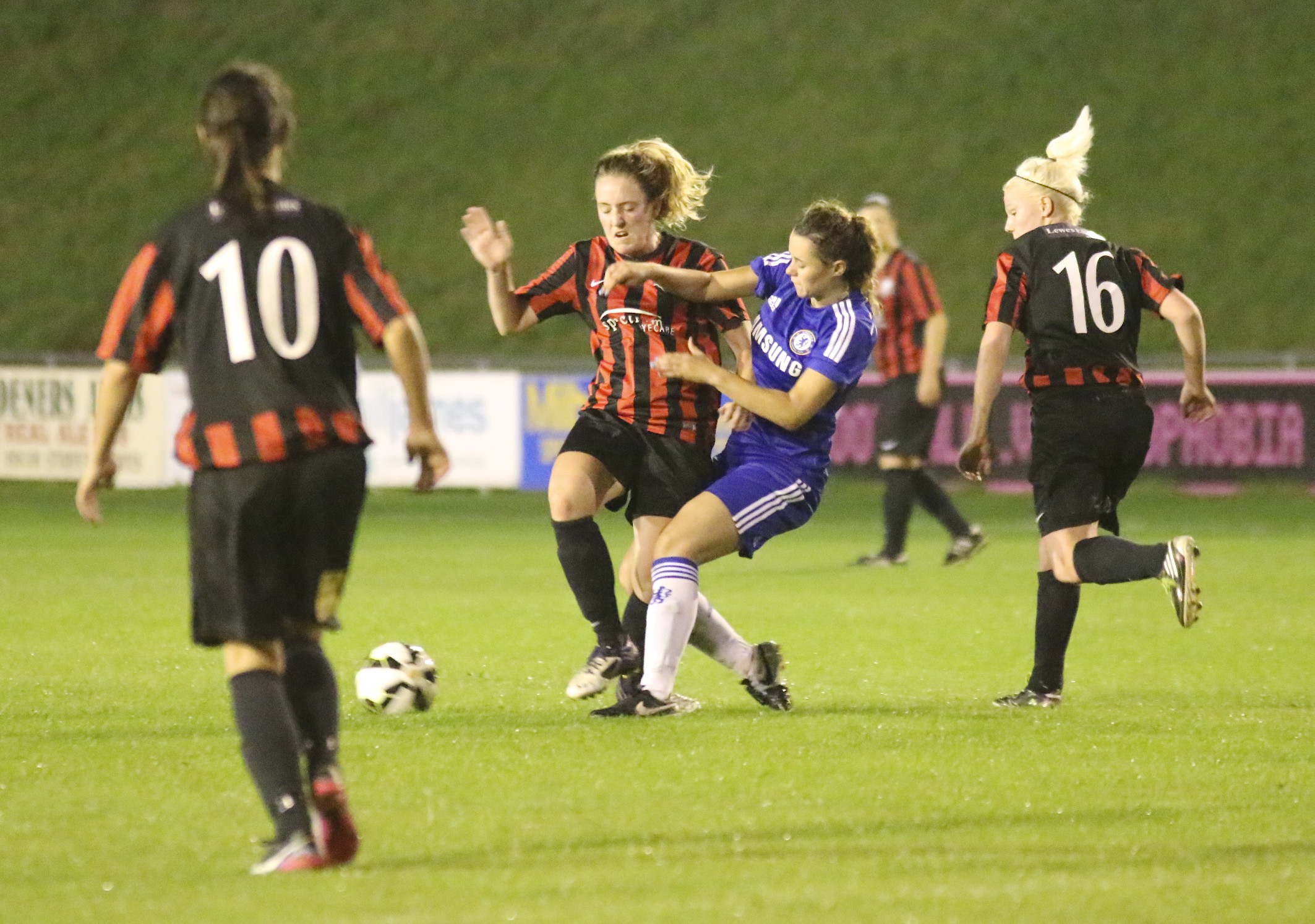 two female soccer teams battle for control of the ball