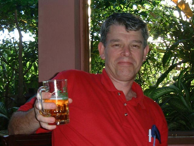 a man wearing a red shirt holding up a glass