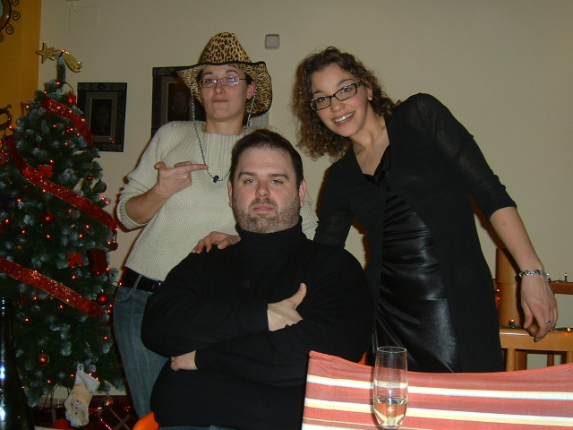 a man standing next to two women on a couch