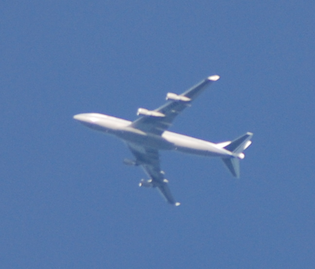 an airplane flies through the clear blue sky