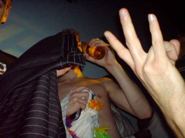 a man wearing a hat and shirt has his hand on the beer bottle