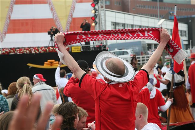 there is a man wearing a hat and holding a scarf