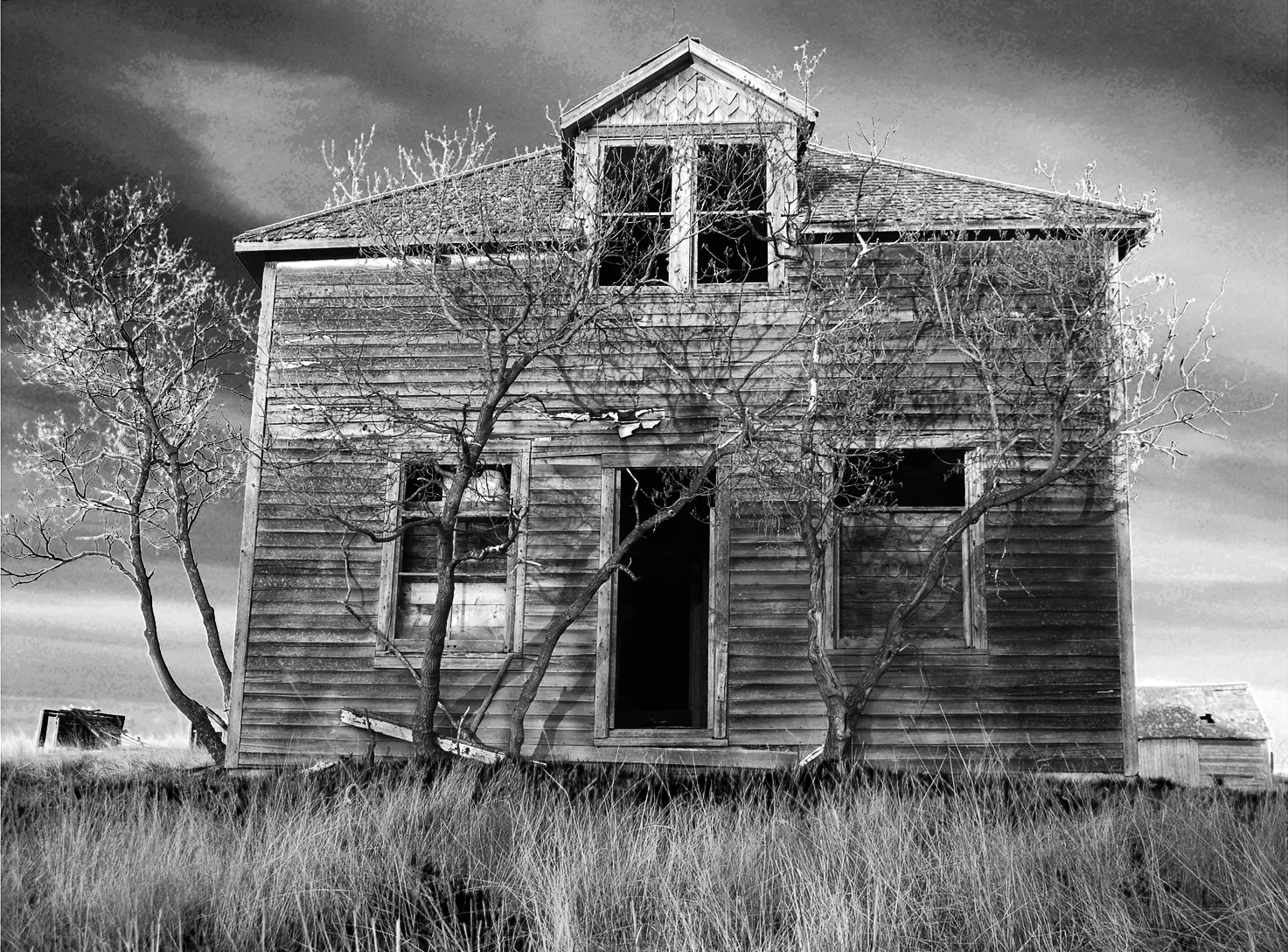 black and white image of old farmhouse with door open