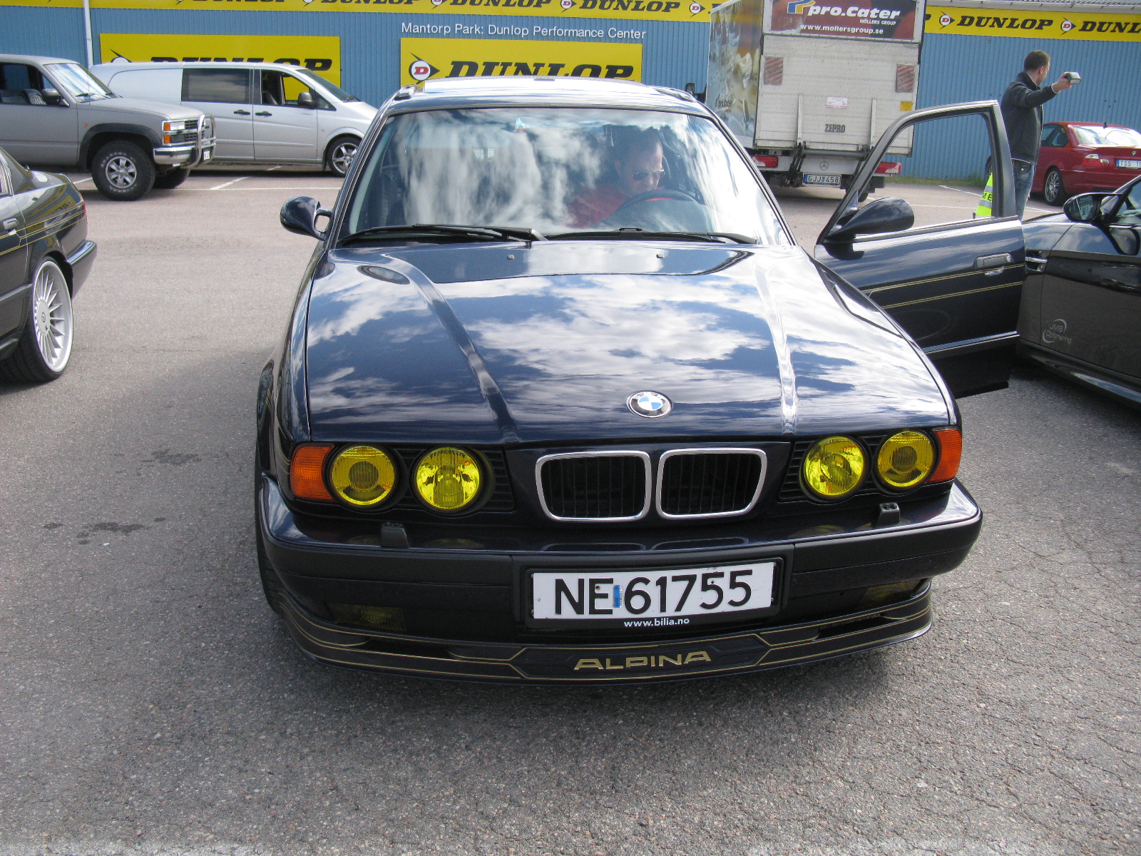 a black car is parked in front of other cars