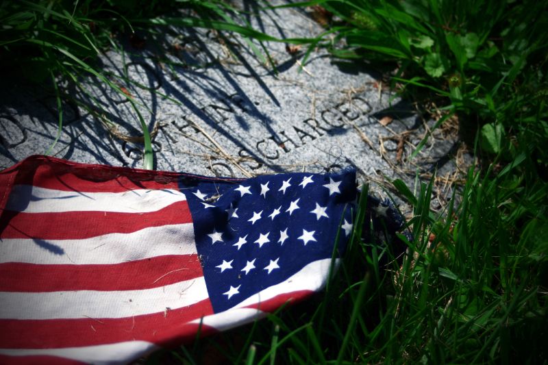 an american flag is laying in grass next to the inscription memorial