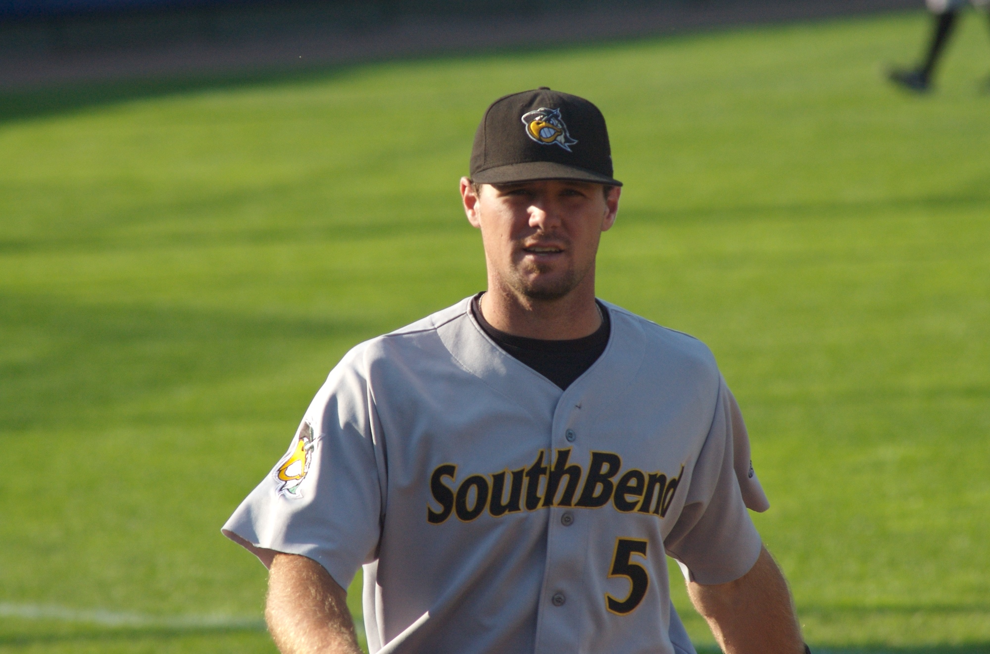 a baseball player holding his mitt as he walks on the field