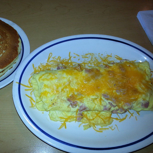 a breakfast sandwich, and scrambled eggs and a pancake