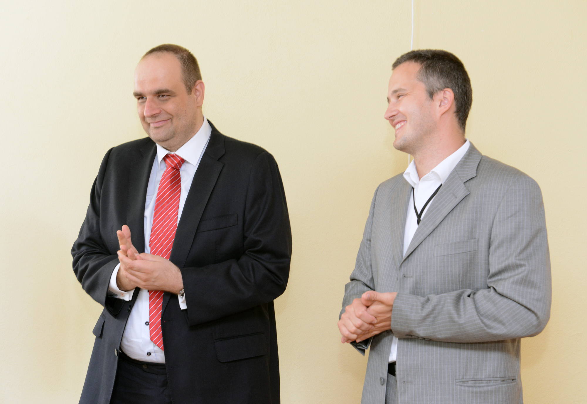 two men are in suits standing next to each other