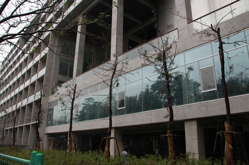 a building that is very large in front of some trees