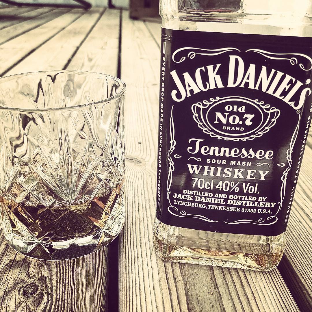a bottle of jack daniels whiskey next to a glass of whiskey
