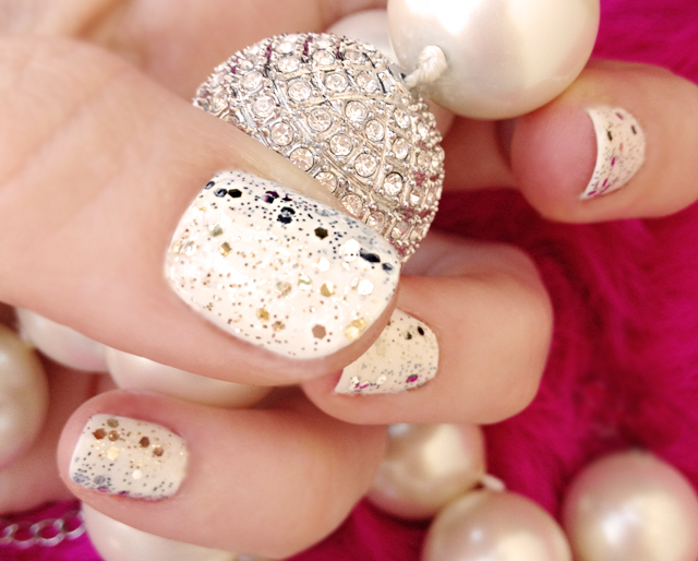 a person wearing some pretty fancy nail polish with pearls