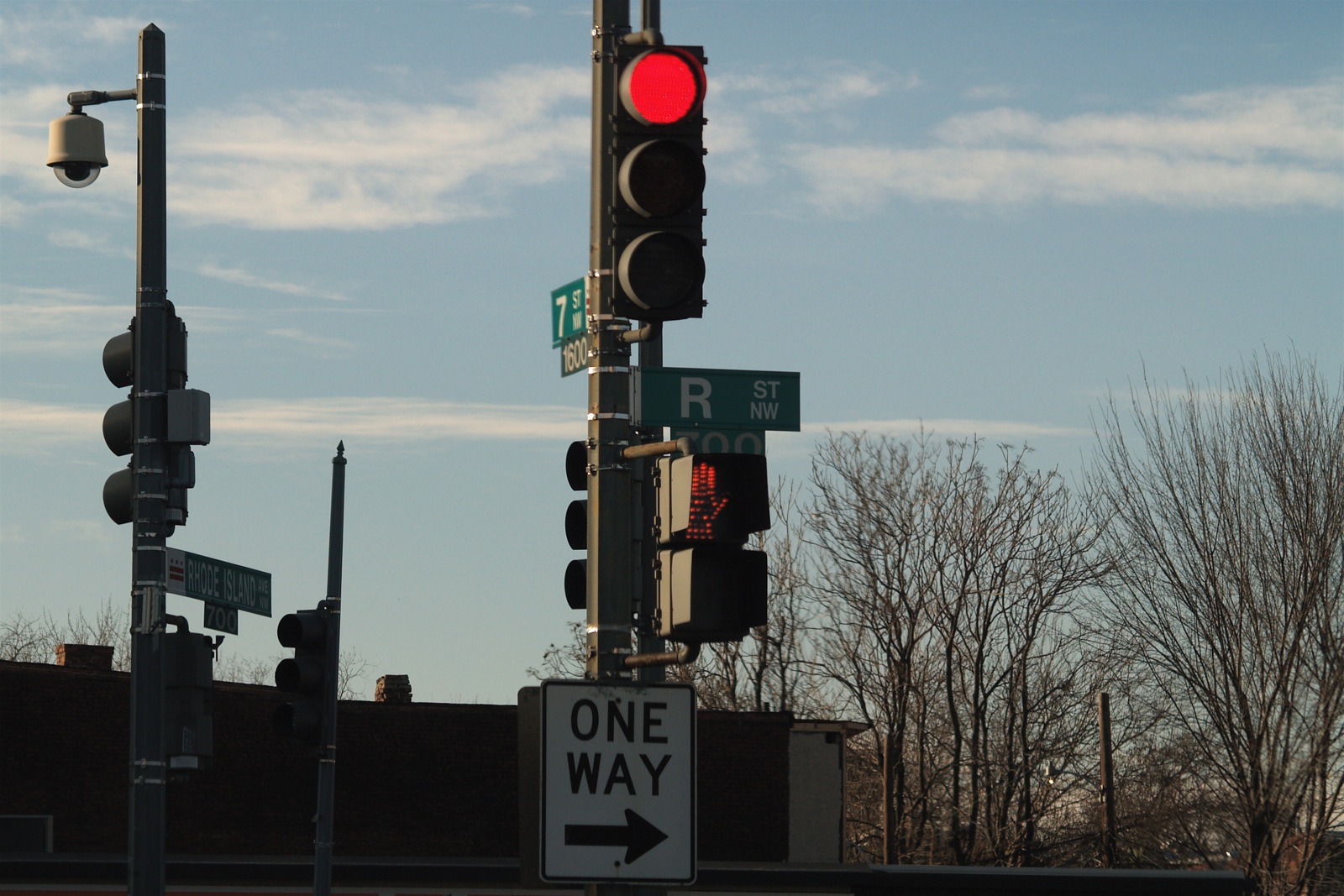 a street sign and stoplight with street lights in the background