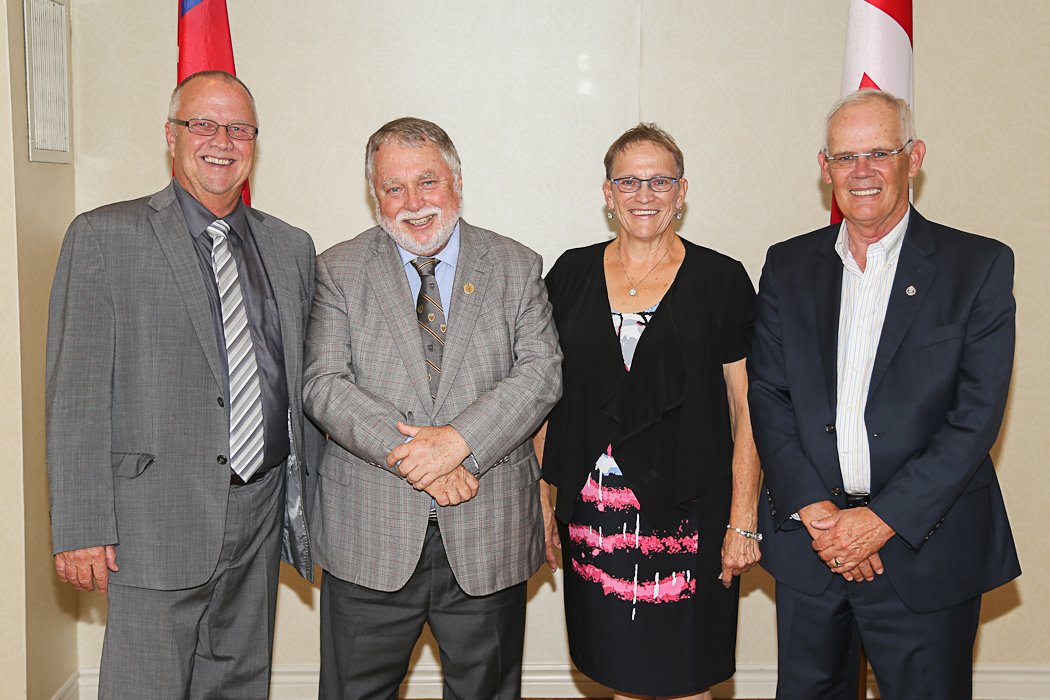 a group of three men and two women standing together