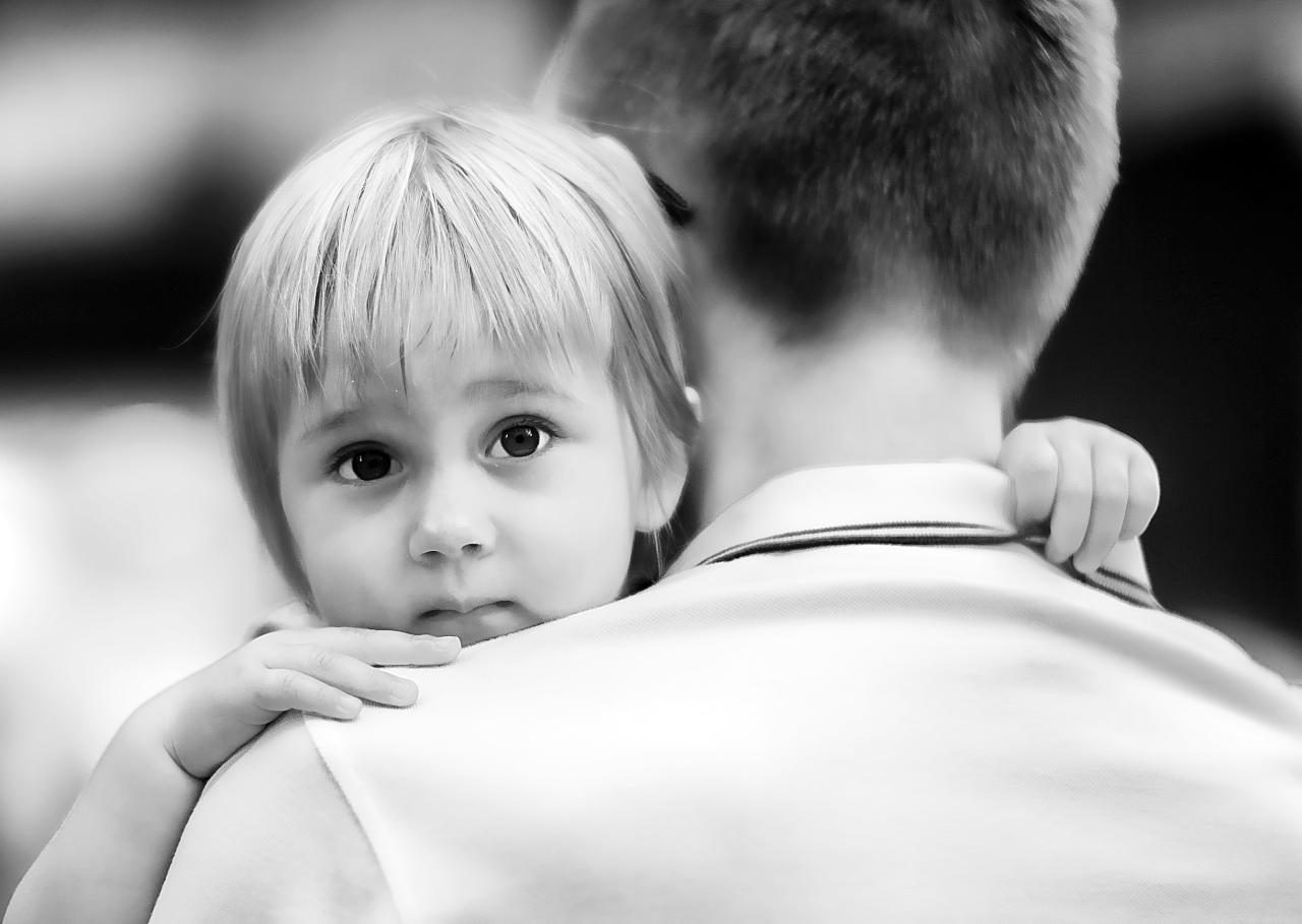 a man holding his little girl and she is cuddling her