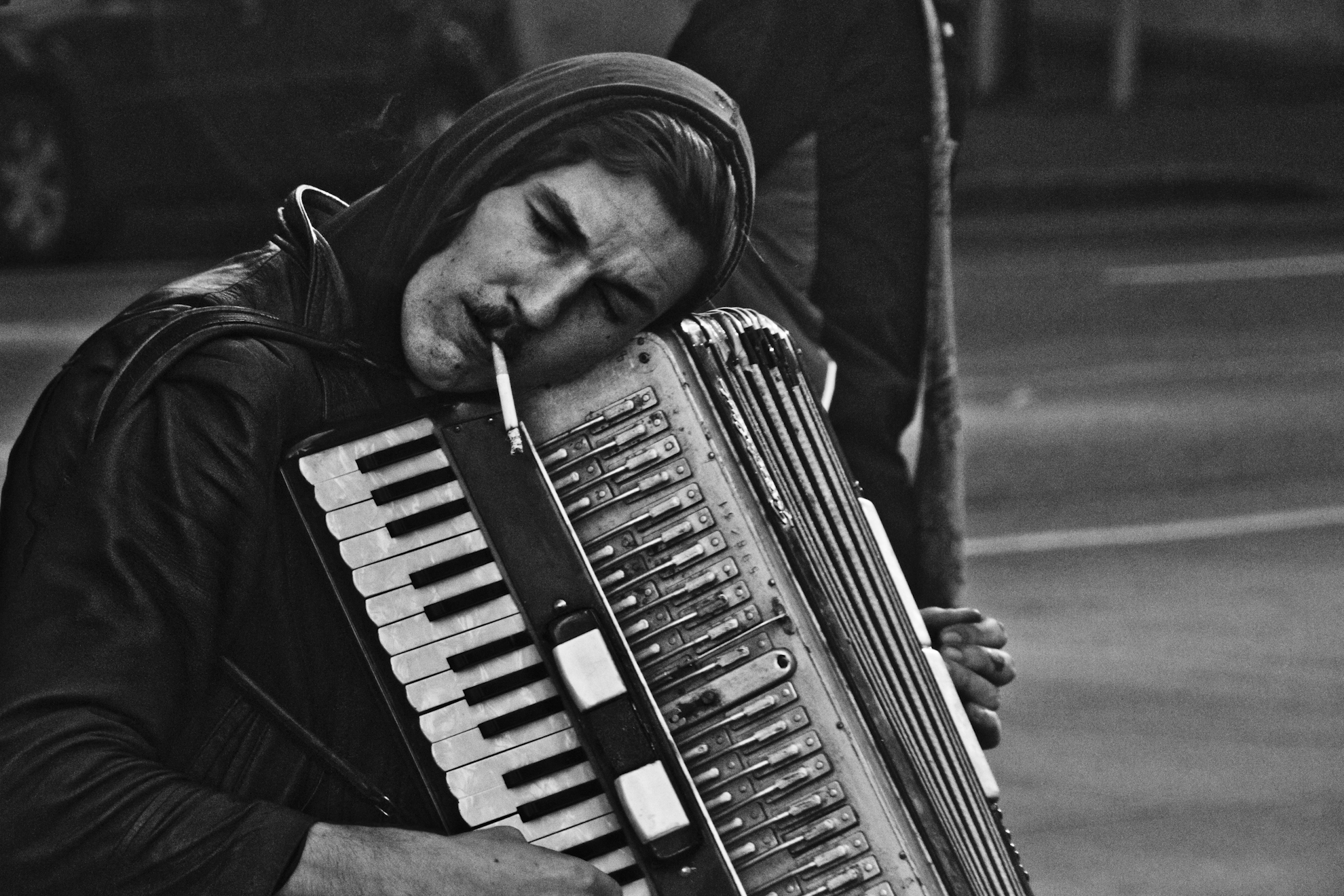 man playing an old accordion on the street