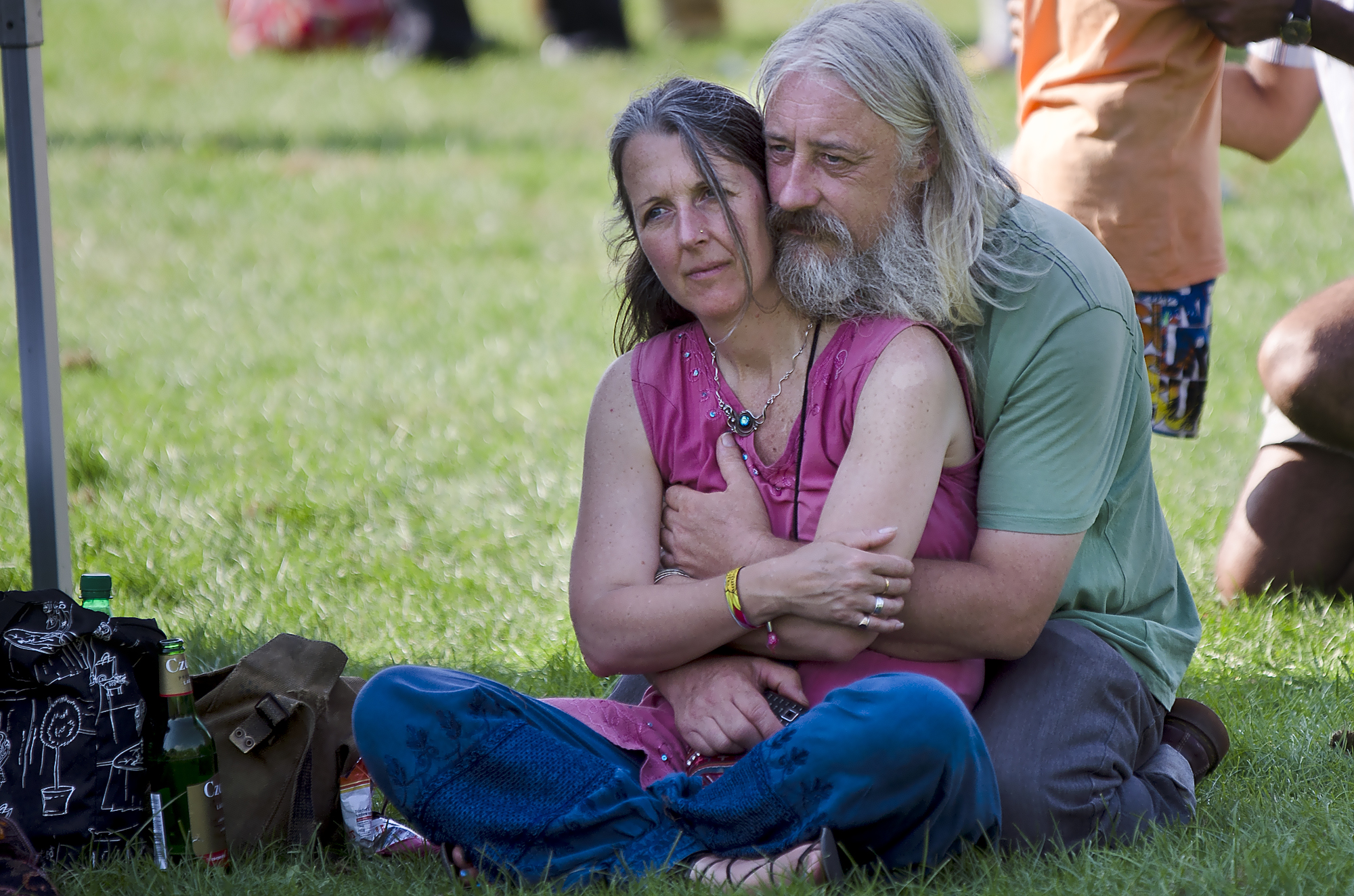 an older couple is emcing each other while sitting on the grass