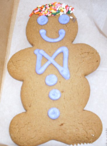 a ginger cookie has a smiley face as well as a wreath on its head